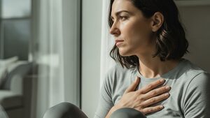 A person sitting by a window looking anxious while taking semaglutide.