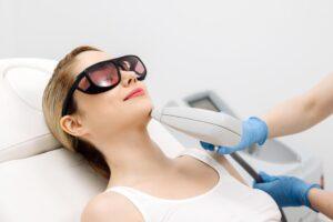 A woman getting laser hair removal on her face. A wellness professional can explain how much laser hair removal costs.